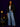 Lady Q’s Corner black collarless tailored blazer with metallic trim worn by a woman with blue jeans and a handbag.