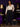 Lady Q’s Corner black high-waisted tailored flare trousers worn by a woman with a silk blouse and black heels.