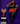 Lady Q’s Corner black knit sweater with flame motifs, checkered sleeves, and speed graphics worn with leather leggings.