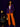Lady Q’s Corner deep purple pinstriped double-breasted blazer worn by a woman with orange trousers and gold handbag.