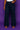 Lady Q’s Corner high-waisted wide-leg indigo denim trousers with architectural panel stitching on a purple background